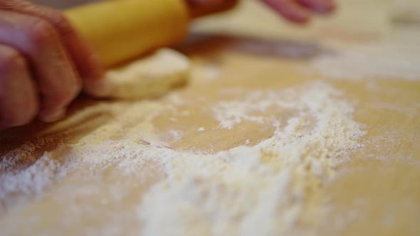 a Woman's Hand Kneads a Piece of Dough Enveloping It in Flour Rolls It Out with a Rolling Pin