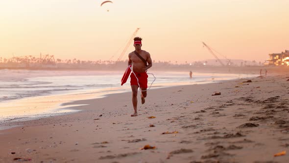 Male lifeguard running along the beach