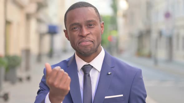 Outdoor African Businessman Pointing at the Camera and Inviting