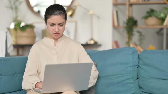 Indian Woman with Laptop Having Wrist Pain on Sofa