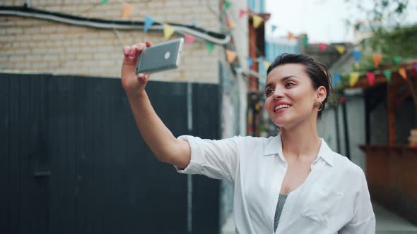 Slow Motion of Pretty Lady Taking Selfie Outside Using Smartphone Waving Hand