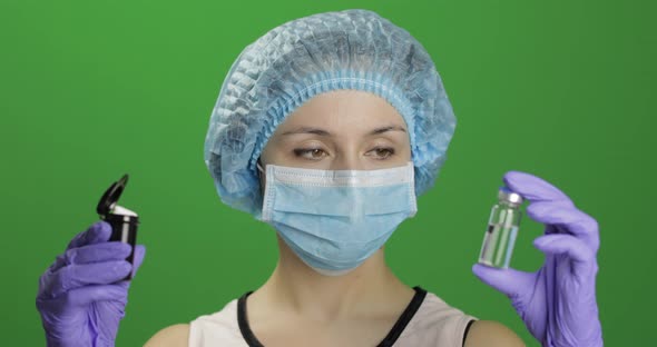 Female Scientist Chooses Ampoule of Vaccination or Plastic Jar with Pills alt