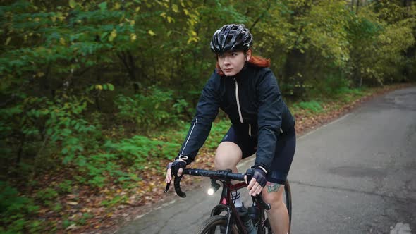 Young Woman Cyclist Wearing Protective Sport Helmet Cycling Alone in Autumn Forest Spending Active