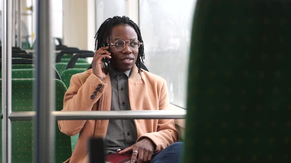 African American Guy in Cadual Clothes Use Phone in Public Transport