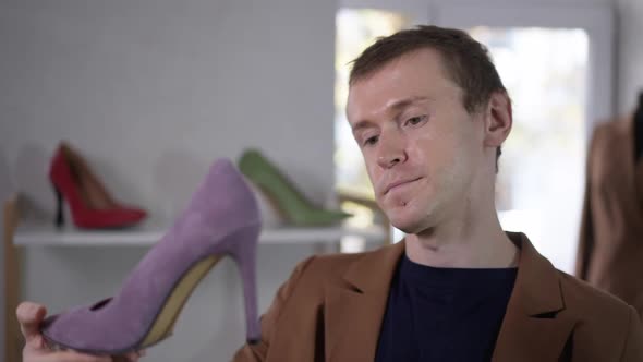 Closeup Portrait of Elegant Confident Gay Man Examining Purple Shoes in Shop in Slow Motion