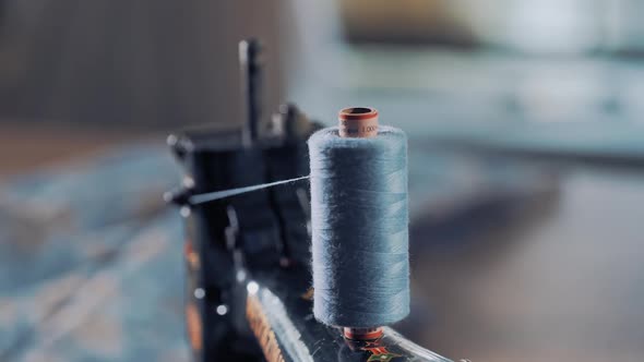bobbin of blue thread on the sewing machine spinning