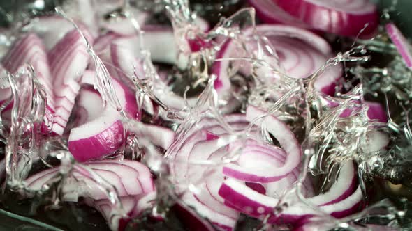 Super Slow Motion Shot of Falling Red Onion Cuts Into Oil in Pan at 1000 Fps