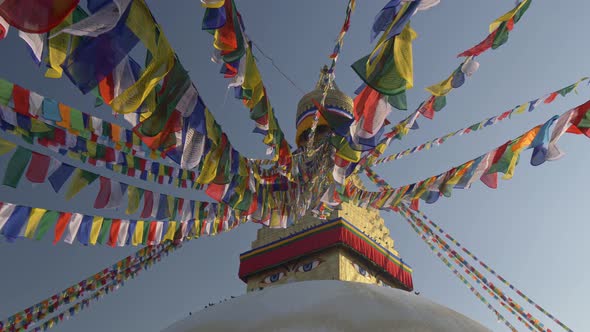 Prayer Flags at Boudhanath Stupa in Sunrise Lights, Kathmandu, Nepal, Crane Shot, UHD