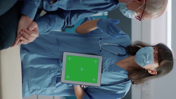 Vertical Video Nurse and Retired Man Looking at Green Screen on Digital Tablet