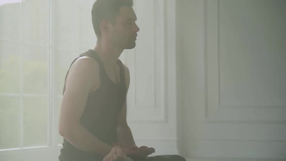 Wellness Man Does Yoga and Meditates a Calm Mood Relaxing in a White Room Filled with Light