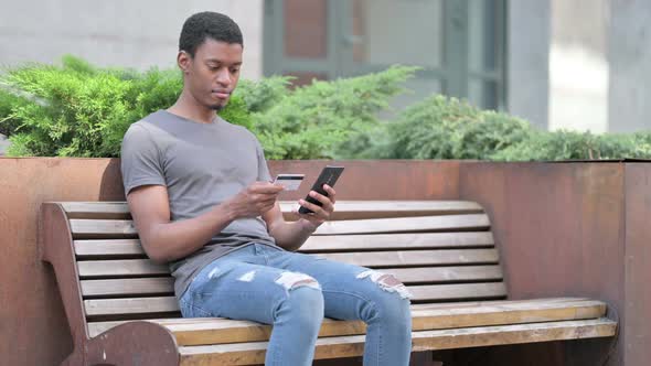 Young African Man Making Successful Online Payment on Smartphone 