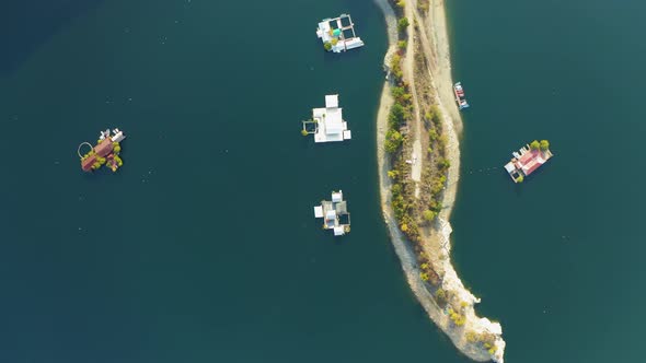 Aerial overhead view of floating houses on a lake near a small island