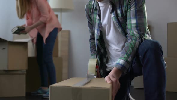 Young Couple Packing Their Things in Boxes, Moving From Dormitory to Own House