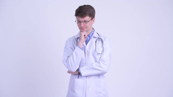 Serious Young Man Doctor Thinking and Looking Down