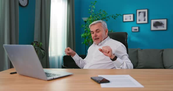 Professional Mature Creative Director Sitting at His Desk in His Home Office Studio Working on