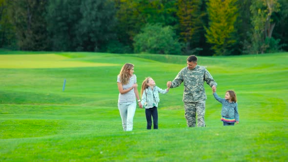 Happy Soldier with His Family in Park.