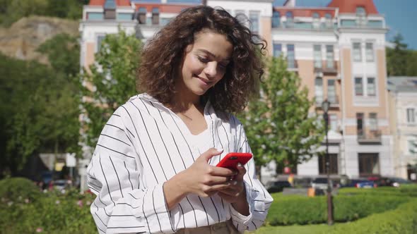 Young Beautiful Hispanic Girl Texting Messages on Her Smartphone