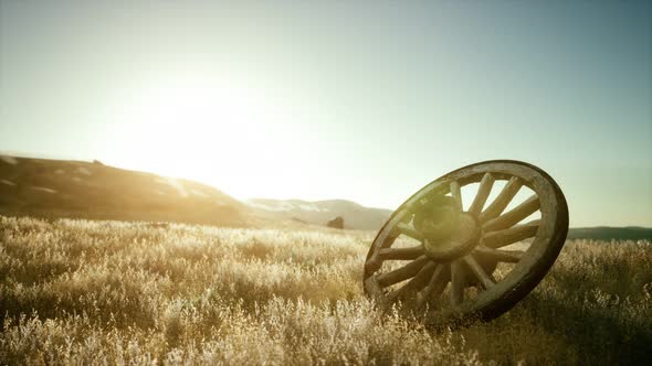 Old Wooden Wheel on the Hill at Sunset