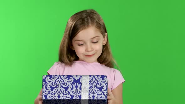 Child Is Holding a Gift in His Hands. Green Screen