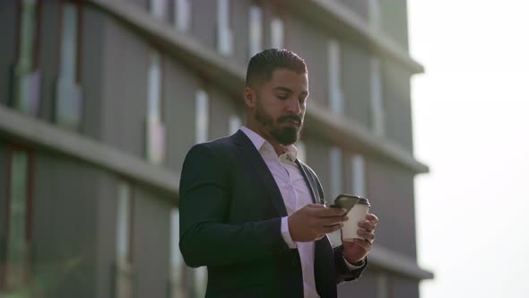 Businessman Holding Paper Cup and Using Smartphone Outdoor