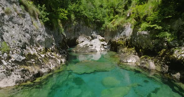 flying over a crystal clear blue water of mrtvica river in canyon