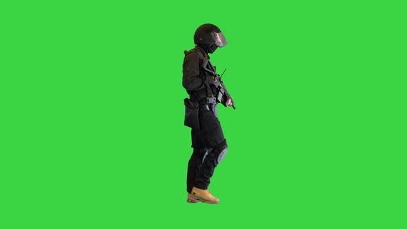 Swat Operator with Assault Rifle Walking on a Green Screen Chroma Key