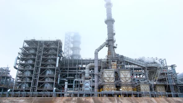 Stop motion footage of an oil refinery, steam and oil pipeline on a cloudy day