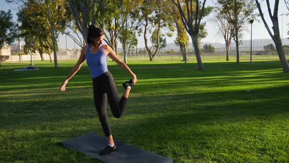 A young woman balancing and stretching before her yoga workout to stay healthy and prevent injury SL