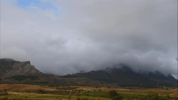 Mountains Against the Backdrop of Gray Clouds. Dark Clouds Cover the Tops of the Mountains