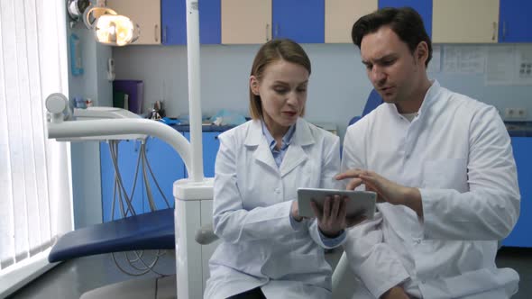 Dentists Discussing Patient's Diognosis on Tablet