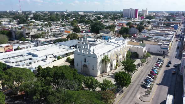 Aerial camera doing an orbit to the left around the front of the colonial Church of Santiago Apostol