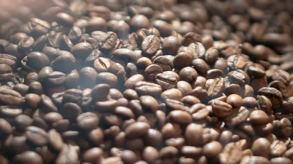 A Closeup Video of a Pile of Dark Coffee Beans and Seeds with an Aromatic Smoke