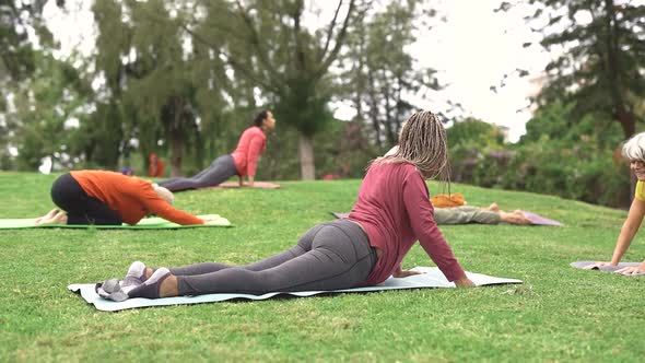 Multi generational people doing yoga class at park with social distance for coronavirus outbreak