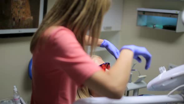 Close up of dental equipment in hospital with patient lying on exam chair and dentist working.