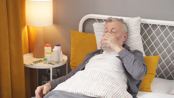 Elderly Man Takes Pills Washed Down with Water