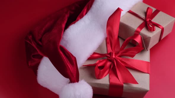 Gift Boxes in Santa Hat on Red Background