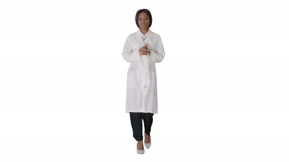 Young African American Female Doctor Talking As She Walks on White Background