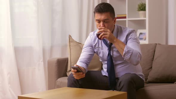 Alcoholic with Smartphone Drinking Wine at Home 