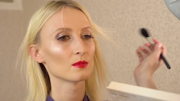 Master Applies Powder Bronzer Contouring on Young Model with Special Brush