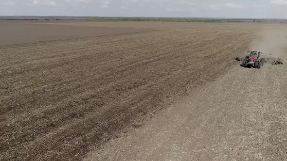 Farmer in Tractor Preparing Land with Seedbed Cultivator