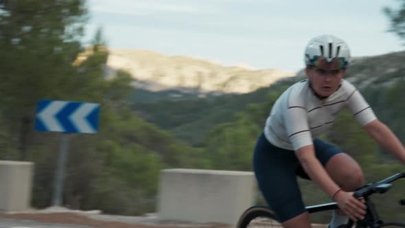 Professional Young Woman Cyclist on Curve Road