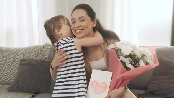 Daughter Gives Her Mother a Card with a Heart and Flowers