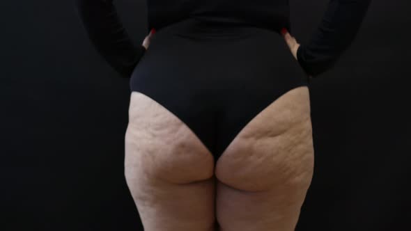 Fat Woman with Cellulite Jumping in Place on Black Background