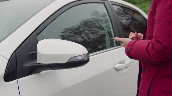 Woman Opening Car Door Using Key App in Her Phone