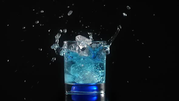 Ice Cubes are Falling to the Cocktail with Splash in Slow Motion on the Black Background Full Prores