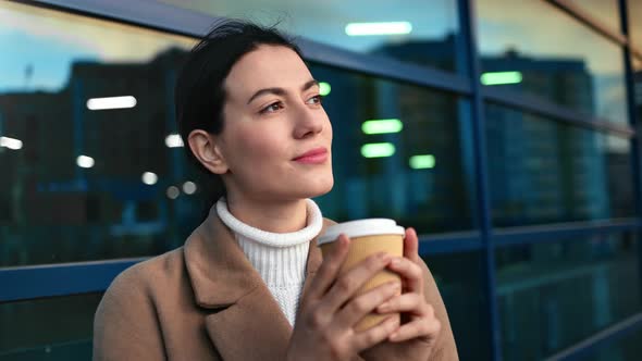 Pleasant Mixed Race Woman Standing Near Glass Building Facade with Coffee