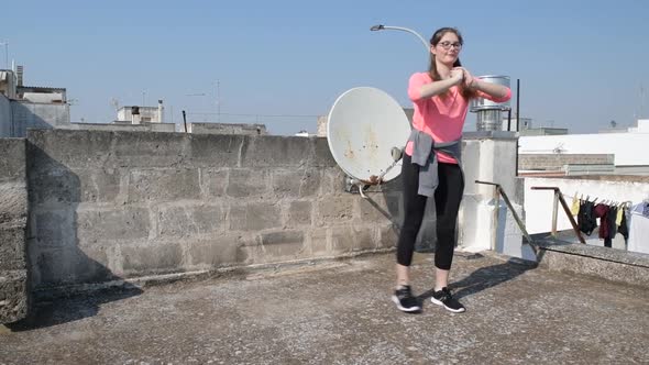 Young girl is doing lateral lunge on the roof