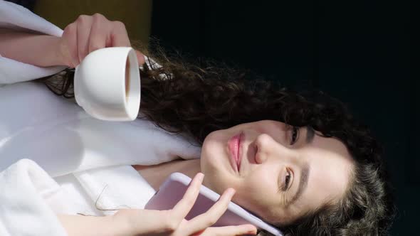 Curly Haired Girl Drinking a Tea at Home While is Talking on Phone After Having a Bath