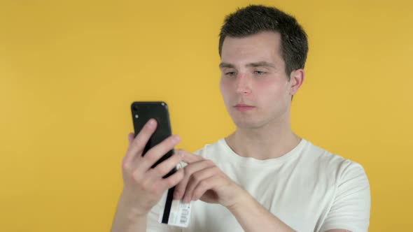 Online Shopping By Man Via Smartphone, Yellow Background