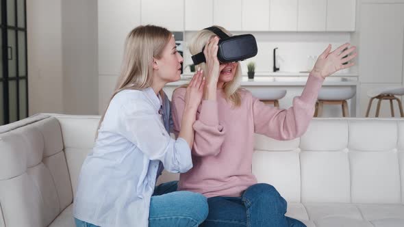 Adult Daughter Showing To Her Older Mother Using New Technology To Exploring the Virtual World While